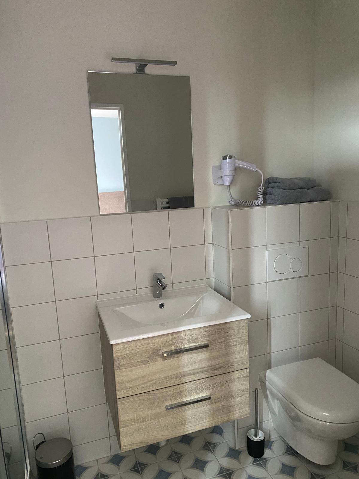 Sanitaire rénové avec meuble vasque, miroir et faïence murale