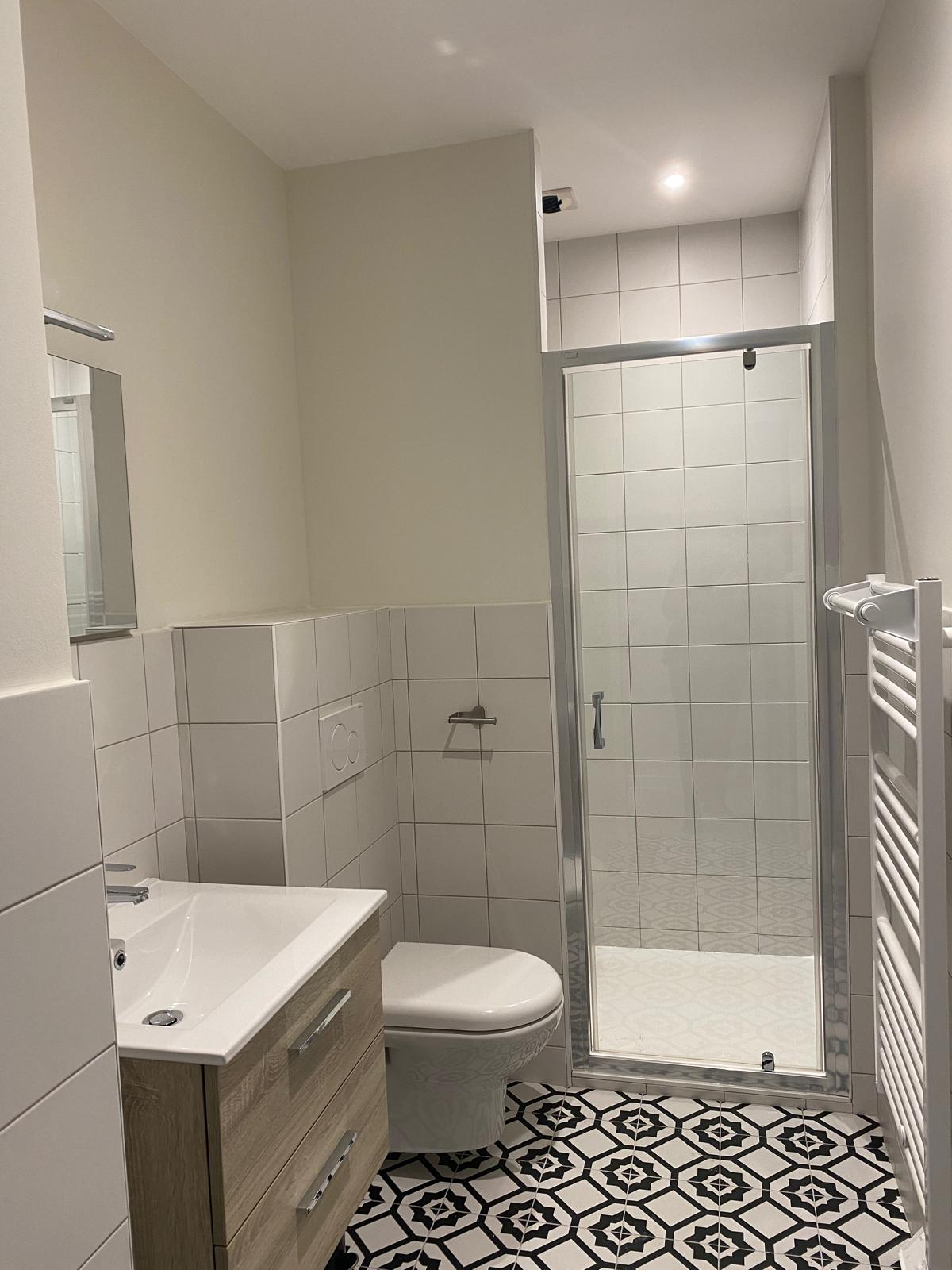 Salle d'eau avec douche à l'italienne, meuble vasque et sèche-serviettes