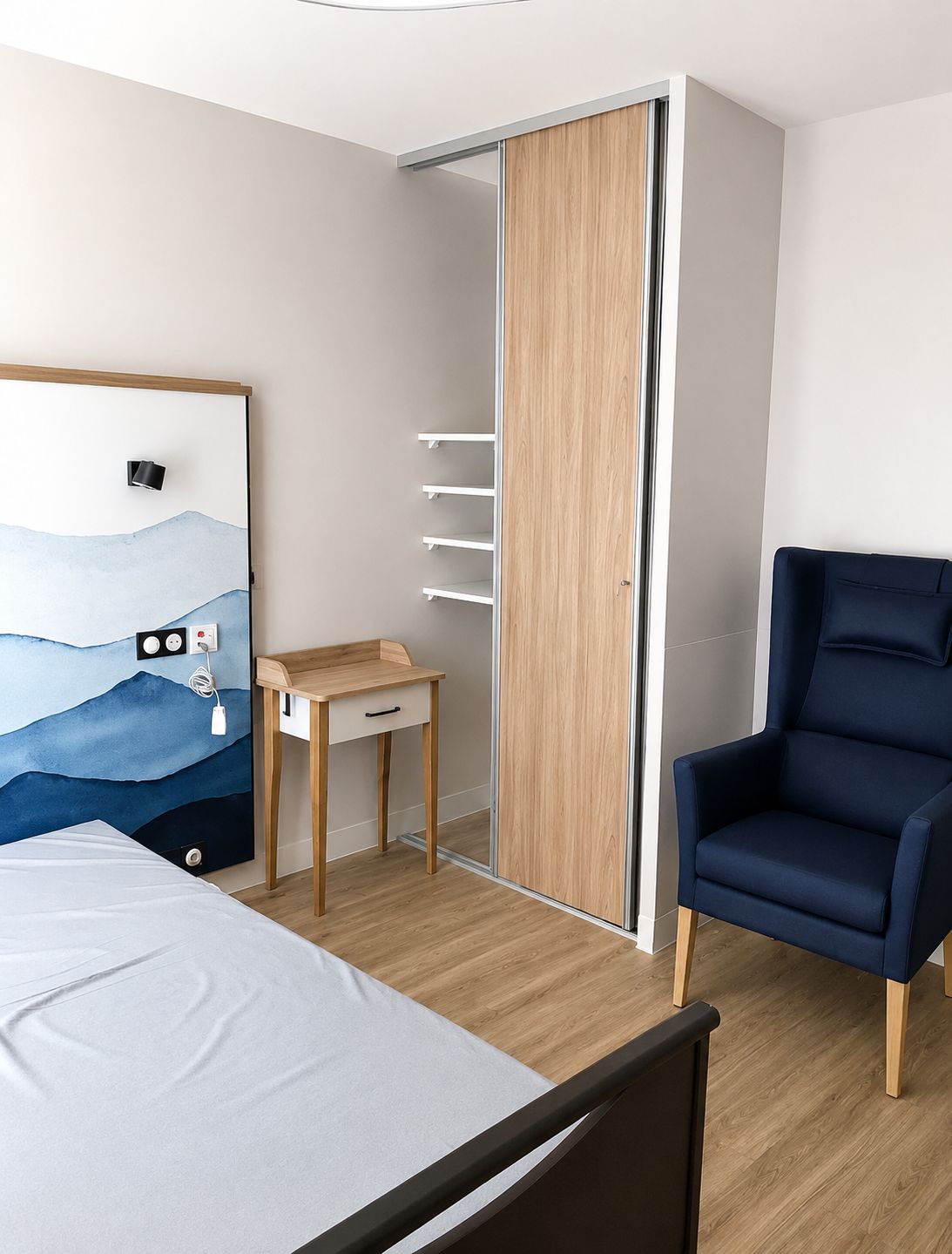 Chambre rénovée avec placard, fauteuil et tête de lit décorative