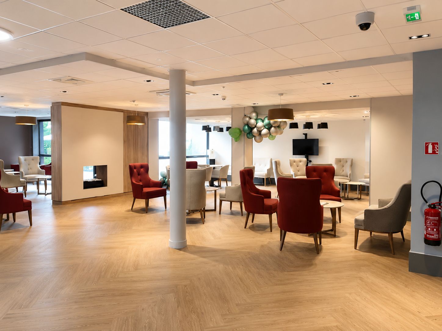 Espace commun Korian rénové avec fauteuils, sol bois et faux plafond
